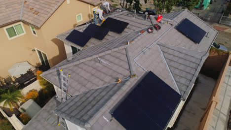 Trabajadores-Ocupados-Montando-Paneles-Solares-En-El-Techo-De-Una-Casa-Contemporánea-En-Los-ángeles,-California,-En-Un-Día-Soleado