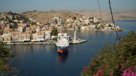 Un-Alto-ángulo-De-Vista-Sobre-El-Colorido-Puerto-De-Ano-Symi,-Un-Ferry-Amarrado-Esperando-La-Salida