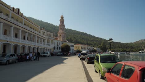 Streetview-of-the-small-village,-Panormitis,-in-Symi-Island,-Tower-of-the-Monastery-of-Archangel-Michael