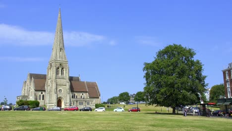 Static-Shot-of-All-Saints-Church-on-Blackheath,-with-Huge-Oak-Tree-in-the-Breeze