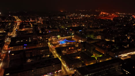 Toma-Aérea-De-Una-Plaza-Iluminada-En-El-Centro-De-Oulu,-Tarde-De-Invierno-En-Finlandia