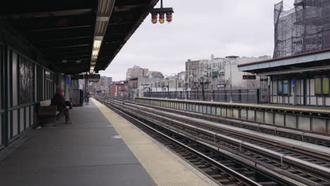 Lonely-women-with-face-mask-waiting-for-subway-on-platform