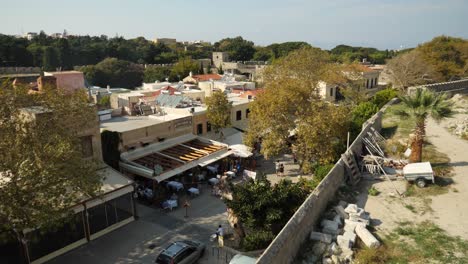 Vista-De-ángulo-Alto-En-La-Calle-Peatonal-De-La-Ciudad-De-Rodos,-Se-Pueden-Ver-Paredes-De-Piedra-Al-Fondo