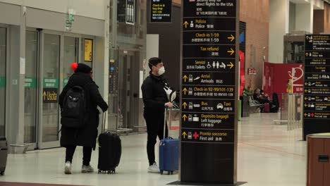 Young-man-in-protective-mask-waiting-in-Venice-Marco-Polo-airport,-after-italy-cancelled-the-carnival