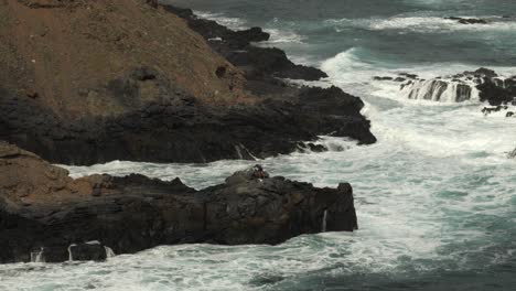 Pescador-En-Las-Rocas-Rodeado-De-Grandes-Olas-Cerca-De-La-Playa-De-Los-Troches