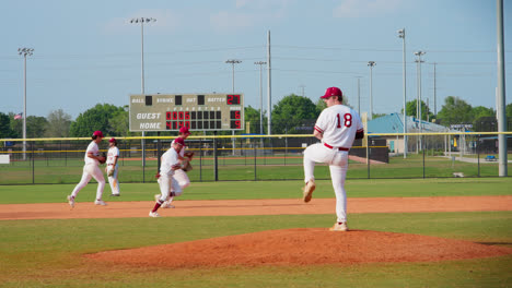 Baseball-Pitcher-Wirft-Während-Der-Auszeit-Den-Ball,-Während-Teamkollegen-Im-Hintergrund-In-Zeitlupe-Vorbeilaufen