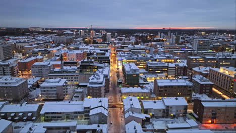 Vista-Aérea-Hacia-Atrás-Sobre-Las-Calles,-Revelando-La-Plaza-Del-Mercado,-Noche-De-Invierno-En-Oulu