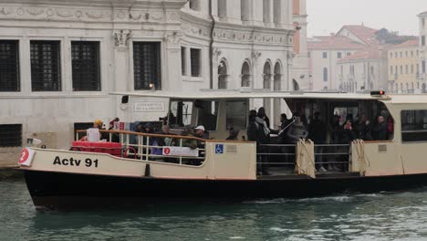 El-Barco-De-Autobús-Acuático-Lleno-De-Gente-Pasa-Por-Debajo-Del-Puente-De-Rialto-En-El-Canal-De-Venecia.