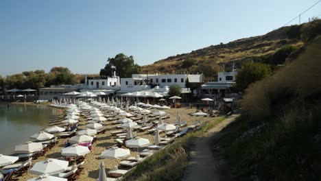 Parasols-and-sunbeds-at-Pallas-Beach,-Lindos