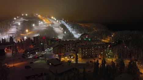 Luftaufnahme-Rund-Um-Den-Beleuchteten-Rukatunturi-Fall,-Winterabend,-In-Ruka,-Finnland---Kreisend,-Drohnenaufnahme