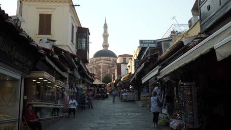 Straßenansicht-In-Rhodos-Stadt-Mit-Geschenk--Und-Souvenirläden,-Suleiman-Moschee-Am-Ende