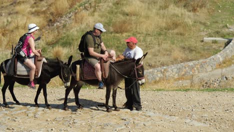 Pareja-De-Turistas-Montando-Dongkeys-En-La-Acrópolis-De-Lindos