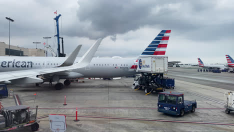 Flugzeuge,-Die-Auf-Einem-Flughafen-Zum-Einsteigen-Aufgereiht-Waren,-Mit-Dunklen-Wolken-Am-Himmel-–-Weitwinkelaufnahme