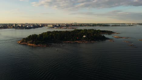 Vista-Aérea-Alrededor-De-La-Isla-Pihalajasaari-Con-El-Paisaje-Urbano-De-Helsinki-Al-Fondo---Dando-Vueltas,-Disparo-De-Drones