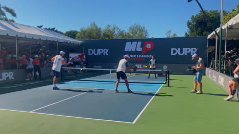 Male-athletes-warming-up-and-training-before-a-pickleball-game,-in-Sunny-Newport-Beach,-California,-USA---Wide-Handheld