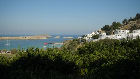 Weiße-Häuser-Von-Lindos-Und-Der-Strand,-Bäume-Im-Vordergrund