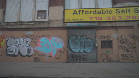 Graffiti-on-wall-in-desolated-street-slo-mo-driving-by-with-people