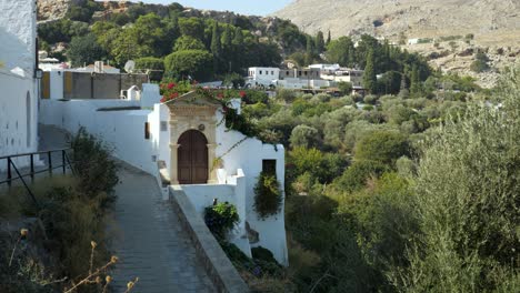 Weiße-Stadthäuser-Auf-Dem-Hügel,-Zwischen-Den-Bäumen-In-Lindos