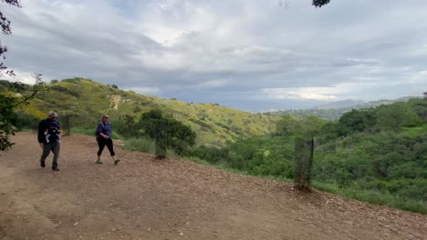 Paar-Mit-Baby-Beim-Wandern-Auf-Dem-Bergwanderweg-Betty-B-Dearing-Mit-Der-Stadt-Im-Fernen-Hintergrund-Am-Abend-An-Einem-Bewölkten-Tag,-Los-Angeles,-USA