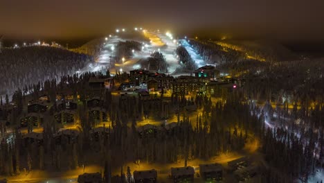 Hyperlapse-Ansicht-Des-Ruka-Skidorfs-Und-Der-Pisten,-Neblig,-Winterabend-In-Kuusamo,-Finnland-–-Rückseite,-Luftaufnahme