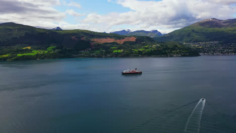 Vista-Aérea-Del-Crucero-Híbrido-Eléctrico-Hurtigruten,-En-La-Costa-De-Noruega:-Panorámica,-Toma-De-Drones