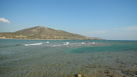 Gente-Caminando-En-El-Mar-Poco-Profundo-Entre-Rodas-Y-Las-Islas-Prasonisi,-Grecia