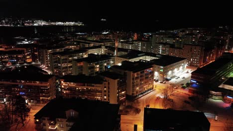 Aerial-view-of-streets-in-downtown-Lauttasaari,-winter-night-in-Helsinki,-Finland---tracking,-drone-shot