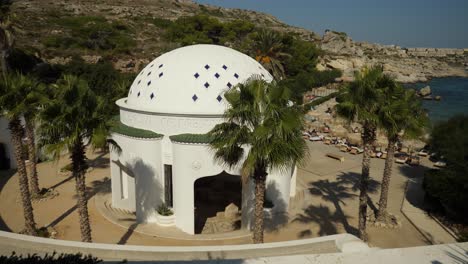 Weißes-Kuppelgebäude-Der-Kallithea-Quellen-In-Strandnähe-Mit-Sonnenbadenden-Menschen