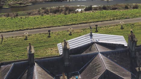 Aerial-over-the-roof,-atrium-and-lawn-of-Glynllifon-mansion