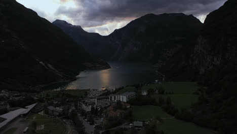 Vista-Aérea-Del-Fiordo-De-Geiranger-Y-Del-Hotel-Union-Geiranger-Mientras,-En-La-Sombría-Noruega,-Descendiendo,-Disparo-De-Un-Dron