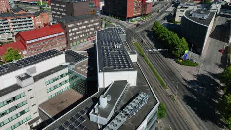 Vista-Aérea-Alrededor-De-Un-Edificio-Con-Paneles-Solares-En-La-Azotea-En-La-Ciudad-De-Tampere,-Verano-En-Finlandia---Dando-Vueltas,-Disparo-De-Drones