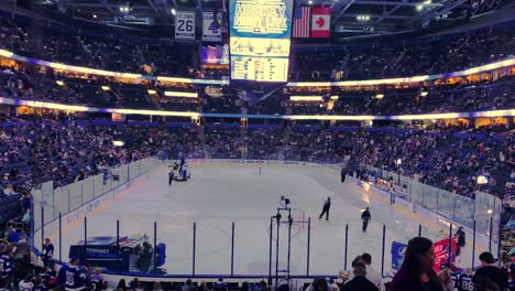 Watching-Hockey-Game---POV-From-Person-Looking-On-An-Ice-Resurfacer-Lays-Down-A-Layer-Of-Water-To-Form-A-Smooth-Ice-Surface-On-An-Indoor-Ice-Hockey-Rink