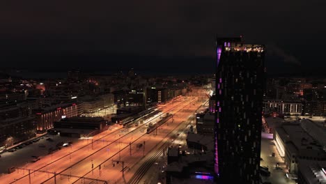 Aerial-view-of-Illuminated-hotel-Torni-and-the-train-station,-in-Tampere,-Finland