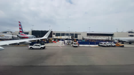 Vehicles-driving-slowly-across-the-tarmac-as-aircraft-external-power-start-unit-is-towed-into-position