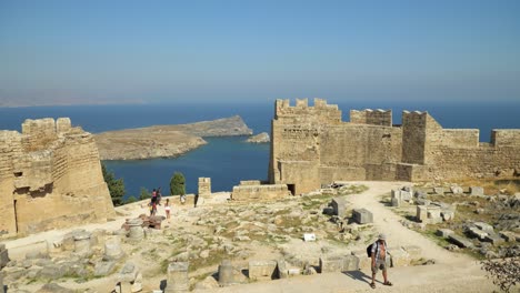 Blick-Auf-Die-Küste-Durch-Die-Mauern-Der-Akropolis-In-Lindos,-Mit-Menschen