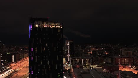 Aerial-view-passing-the-Torni-hotel-revealing-buildings-at-the-train-station,-winter-in-Tampere,-Finland