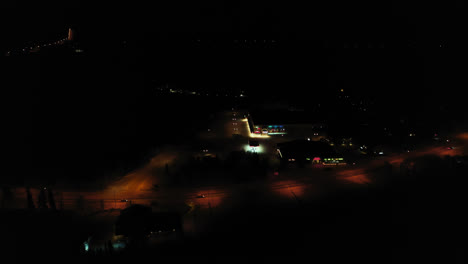 Aerial-view-of-the-Jounin-kauppa-market-and-shopping-center,-winter-evening,-in-Akaslompolo,-Finland---orbit,-drone-shot