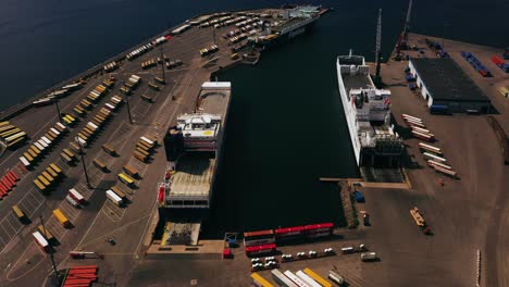 Vista-Aérea-Con-Vistas-A-Los-Transbordadores-De-Carga-En-Una-Terminal-De-Envío,-Día-Soleado-En-Hanko,-Finlandia---Seguimiento,-Disparo-De-Drones