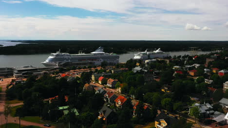 Vista-Aérea-Lejos-De-Los-Barcos-De-Pasajeros-En-El-Puerto-De-Mariehamn,-En-Ahvenanmaa,-Finlandia---Retroceso,-Disparo-De-Un-Dron