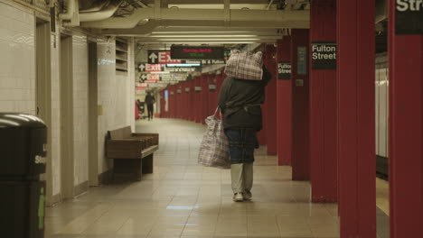 Hombre-Sin-Hogar-Llevando-Sus-Pertenencias-En-La-Estación-De-Metro-De-Fulton-Street-De-Nueva-York-Durante-El-Covid-19