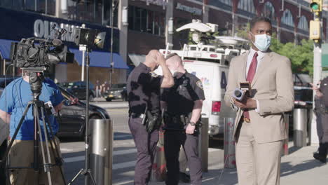 News-TV-Anchor-wearing-Face-Mask-getting-ready-to-go-live-during-BLM-protest-wide-shot