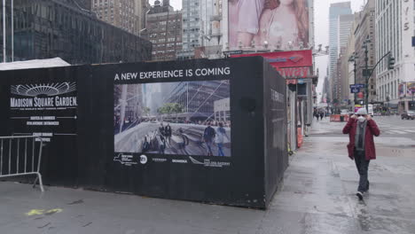 Männer-Setzen-Eine-Gesichtsmaske-Vor-Das-Ironische-New-Madison-Square-Garden-Schild-–-Eine-Neue-Erfahrung-Steht-Bevor