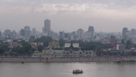 Aléjese-Del-Ferry-En-El-Río-Tonle-Sap-A-Una-Toma-Amplia-Del-Horizonte-De-Phnom-Penh.