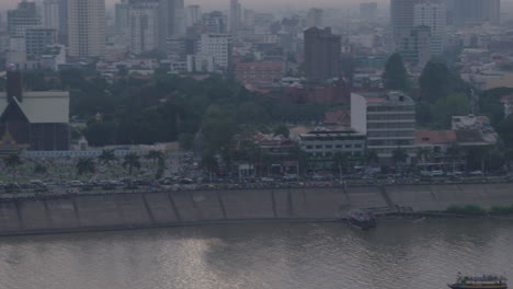 Tilt-up-from-boat-to-Polluted-downtown-Phnom-Penh-and-royal-Palace