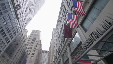 Pan-down-on-empty-street-from-American-flags-and-Manhattan-Mall-in-midtown-Manhattan-during-coronavirus