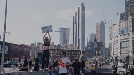 Mujeres-Manifestantes-Sosteniendo-Un-Cartel-Negro-No-Es-Un-Crimen-En-El-Centro-De-Brooklyn-En-Cámara-Lenta