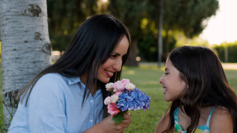 Mutter-Und-Kind-Riechen-Blumen-Im-Park