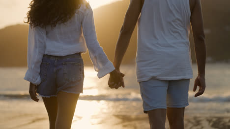 Couple-holding-hands-at-sunset