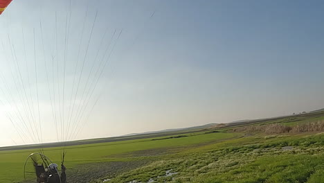 Piloto-De-Parapente-Arrastra-El-Pie-Por-El-Agua-Mientras-El-Vuelo-Roza-El-Suelo.