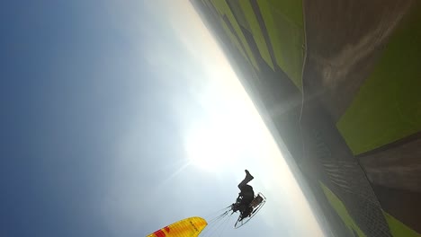 Hochformat:-Luftumlaufbahnen,-Gelber-Motorschirmflieger-Am-Blauen-Himmel